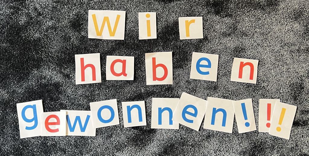 Auf dem Teppich liegen bunte Buchstaben: Wir haben Gewonnen!!!