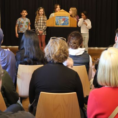 Fünf Kinder stehen auf der Bühne und erzählen eine Geschichte mit dem Kamishibai