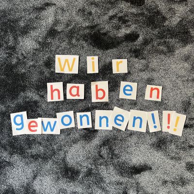 Auf dem Teppich liegen bunte Buchstaben: Wir haben Gewonnen!!!