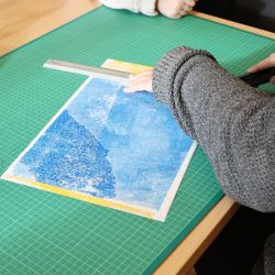 Eine Person schneidet eine selbstgemacht Illustration mit dem Katermesser