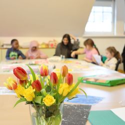 Die Leseclub-Kinder sitzen am Tisch und basteln