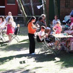 Viele Menschen sitzen im Garten.